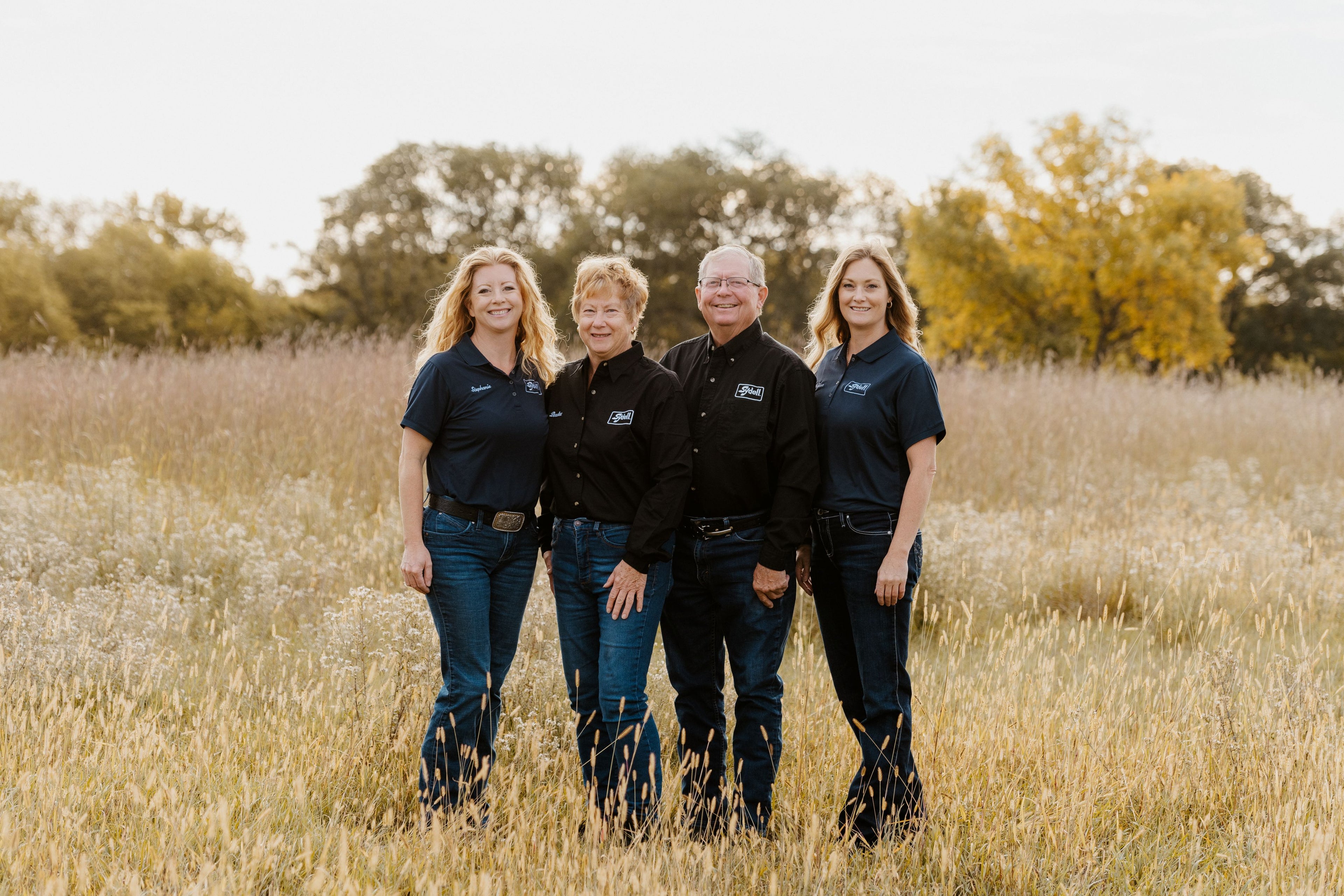 Four people standing in a field with Sydell shirts on